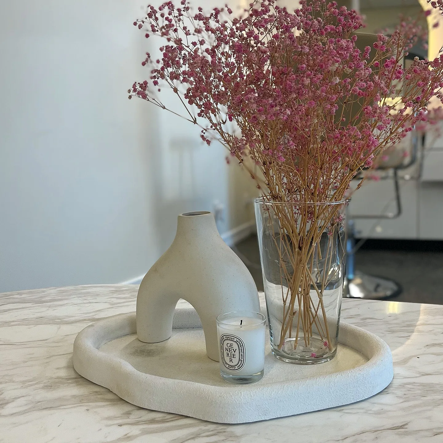 Dried pink florals and Diptyque candle on marble counter — Sculpt Society studio detail