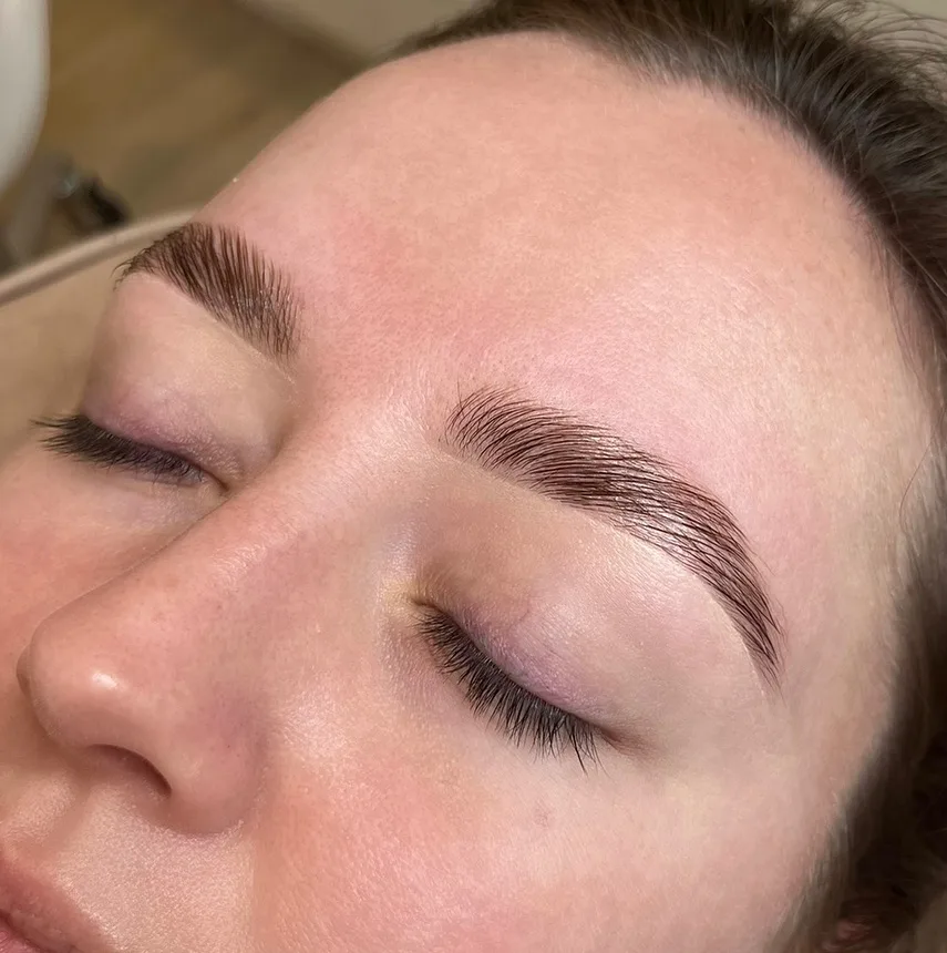 Brow lamination result — softly closed eye, defined arch